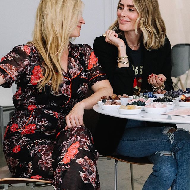 两名女子坐在一张桌子，面带微笑，和善待彼此。