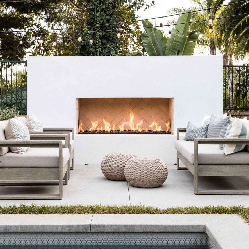 一个白色的户外壁炉，位于配套的白色露台上