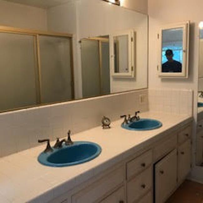 在拍摄亮蓝色水槽的浴室前。