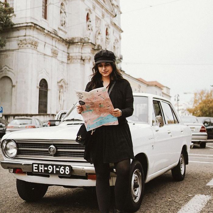 女人在车前看地图站立