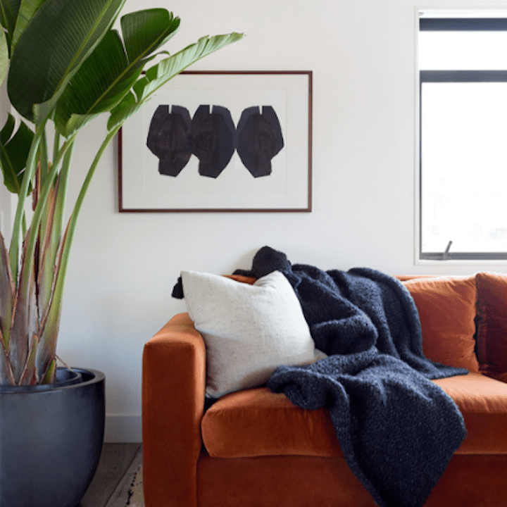 有羊毛毯子和地毯的锈色沙发。