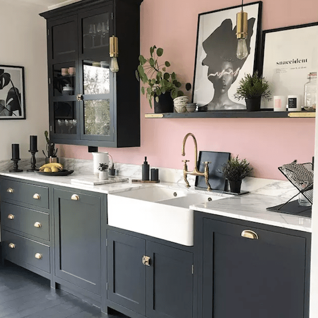 厨房有黑色橱柜和粉色墙面