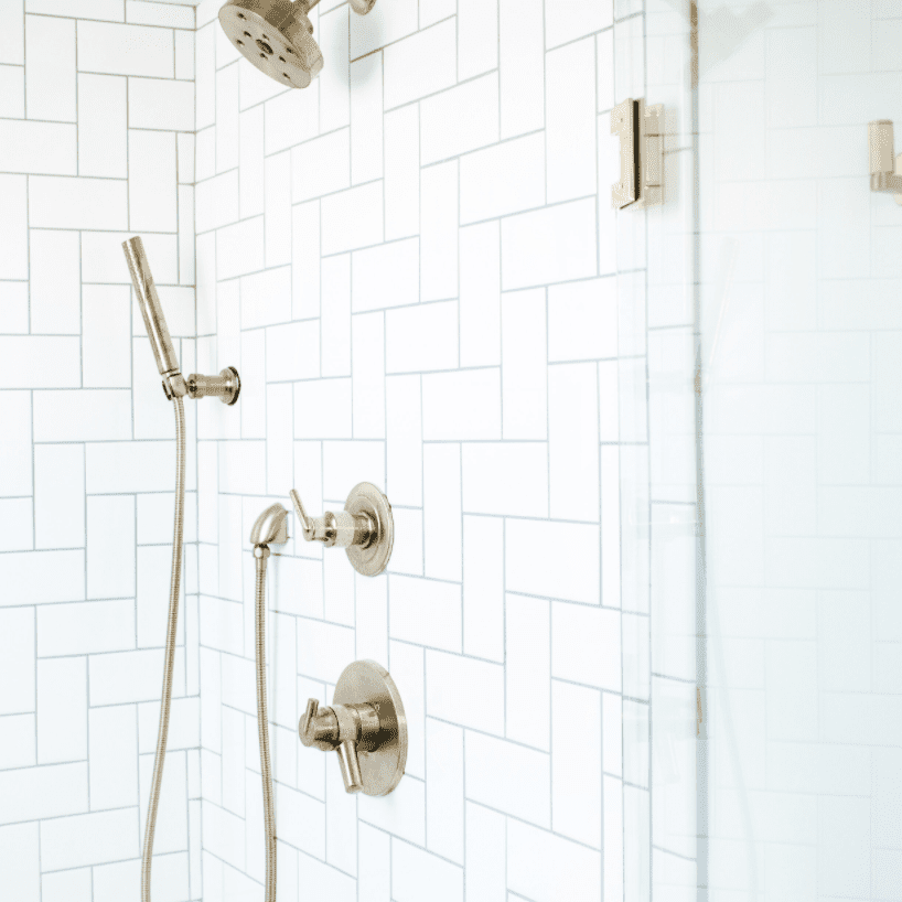 浴室里排列着白色的地铁瓷砖，这些瓷砖被转向不同的方向，形成了一个图案