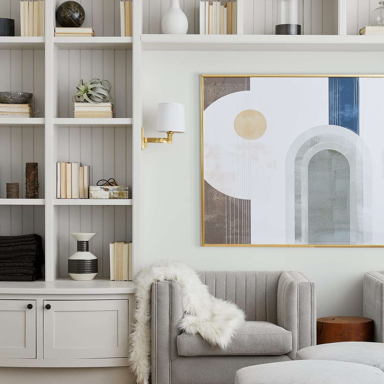 这是一间起居室，白色的书架边的墙壁上装饰着书籍和小玩意