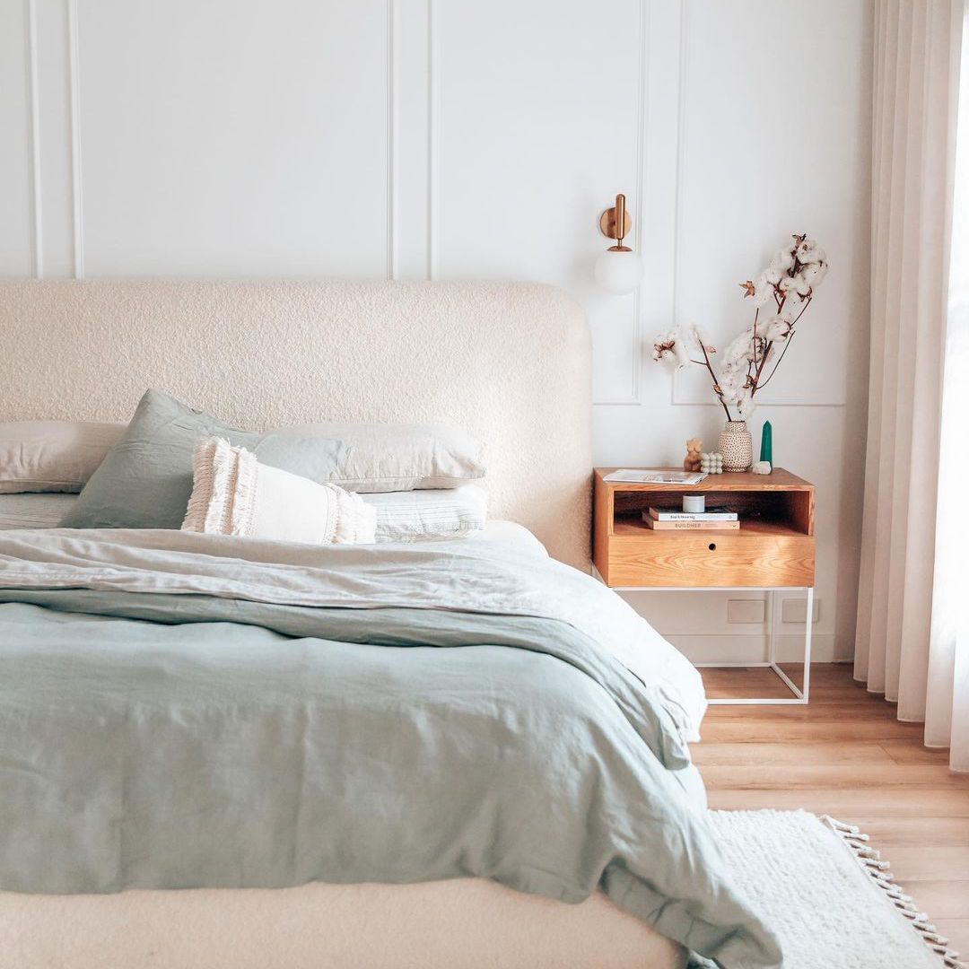 有木床头柜的软的桃红色淡色卧室。