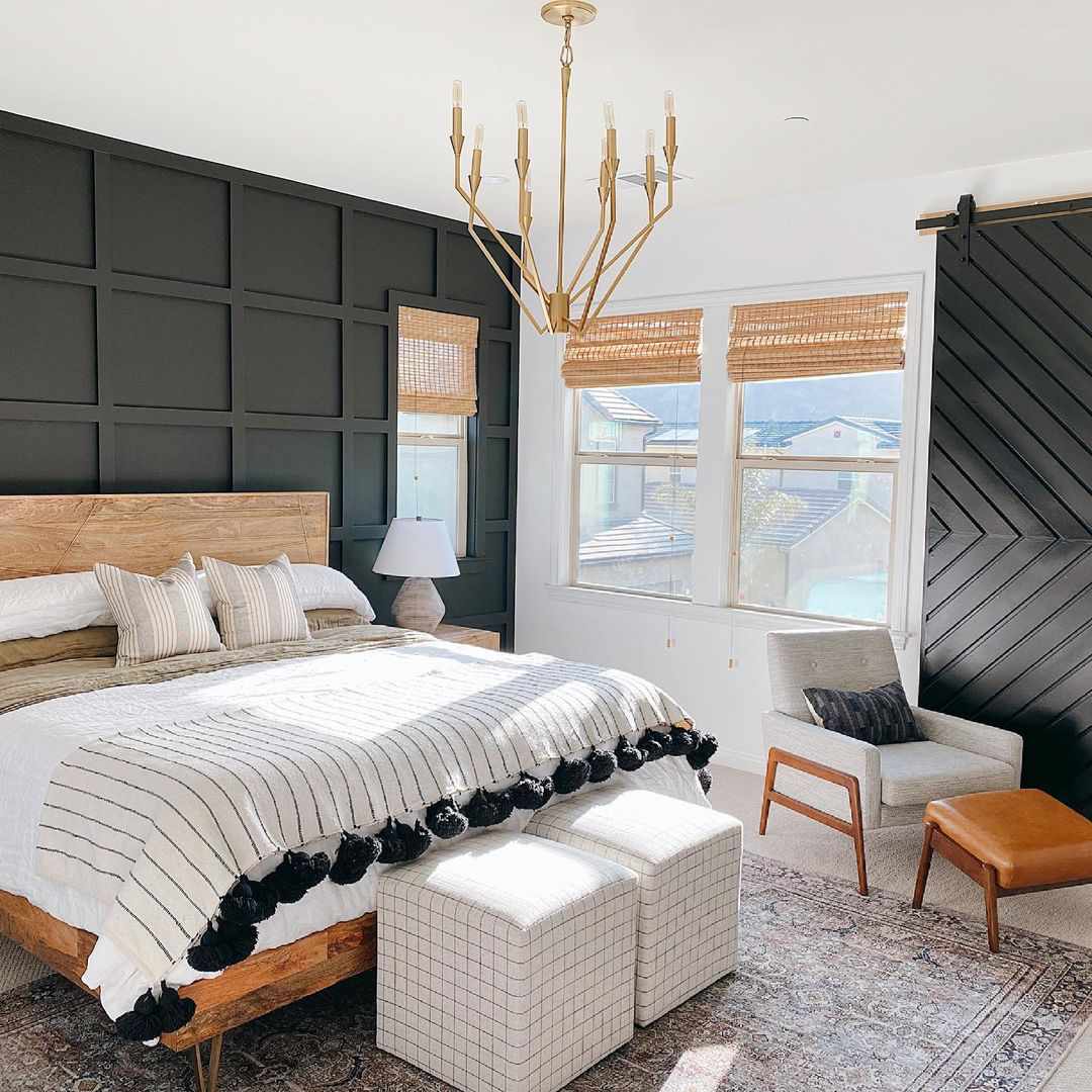 中性卧室配有金属枝形吊灯和木制床框架。