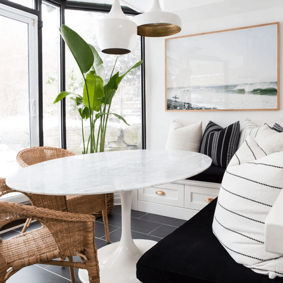 餐饮Nook配有编织椅子，黑白枕头和工业吊灯