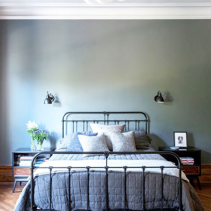 简单的卧室，挂着泡泡吊灯，铁床架，床的两边都有烛台。