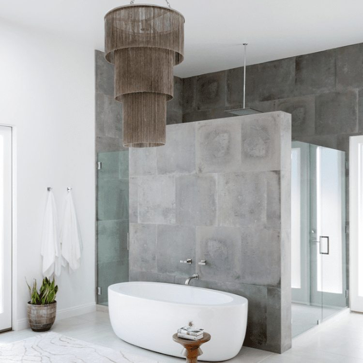 灰色浴室配有水泥墙和一个大枝形吊灯