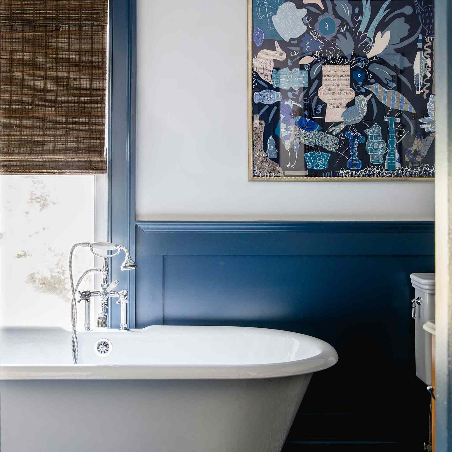 一间带爪形浴缸、印花瓷砖地板和枝形吊灯的单色蓝色浴室