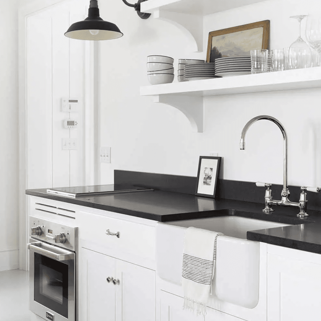 一个白色的小厨房，有一个小炉灶和一个小烤箱