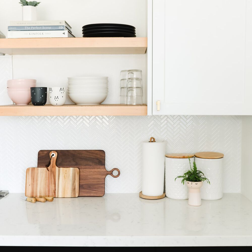 一个简约的厨房，带有白色的人字形瓷砖背板