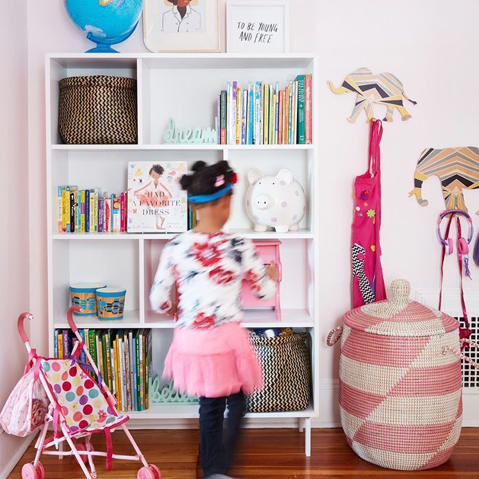 一个小女孩在她房间里的书架旁