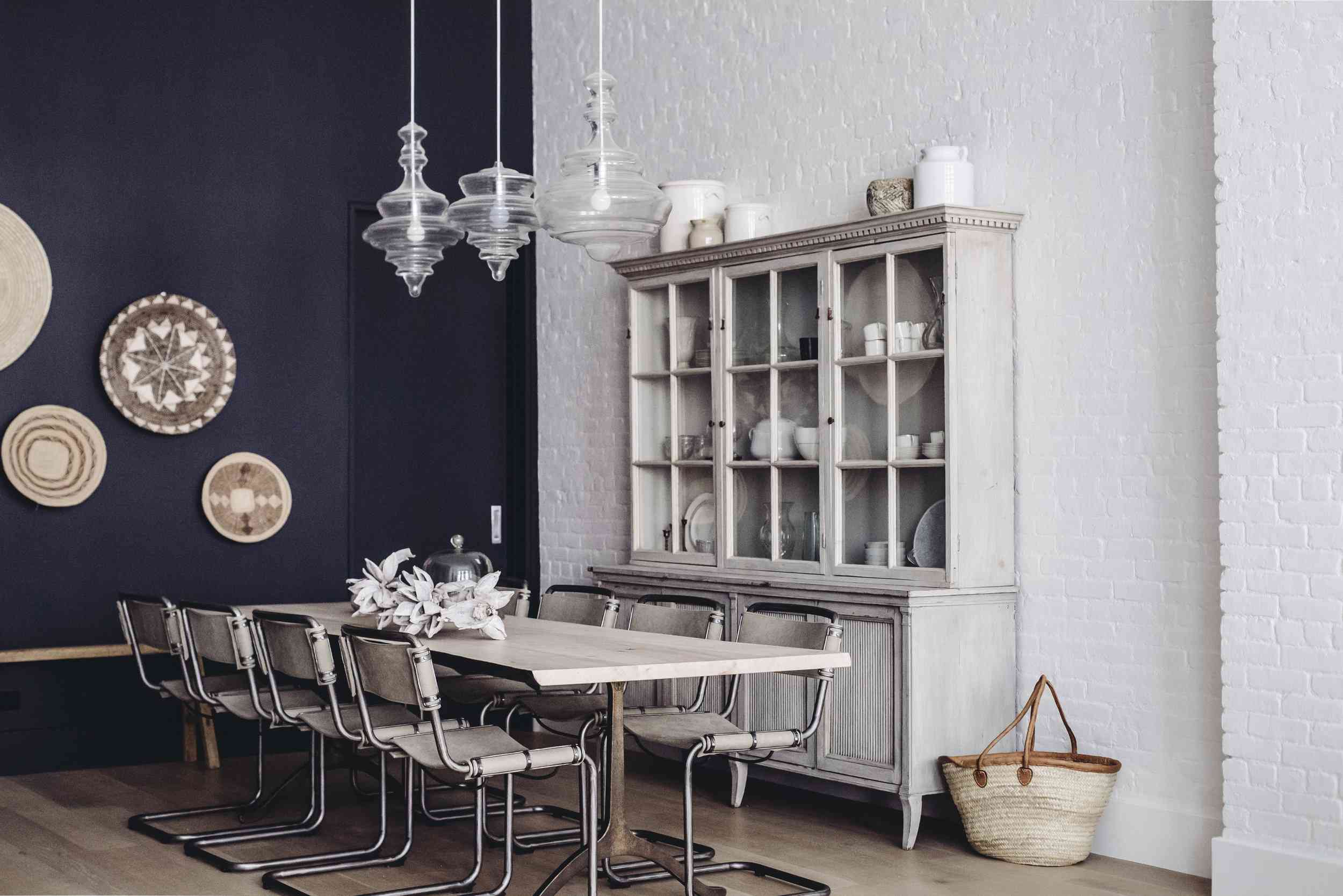 一间有白色砖墙、灰白色家具和海军蓝墙壁的餐厅