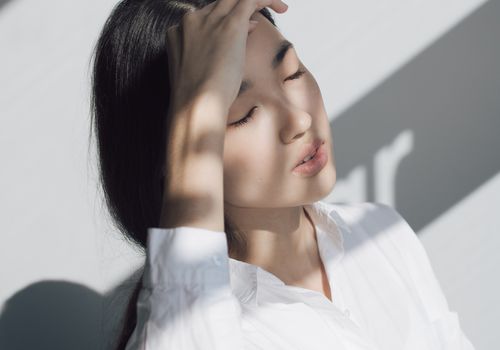 女人与她的手放在她的头闭着眼睛