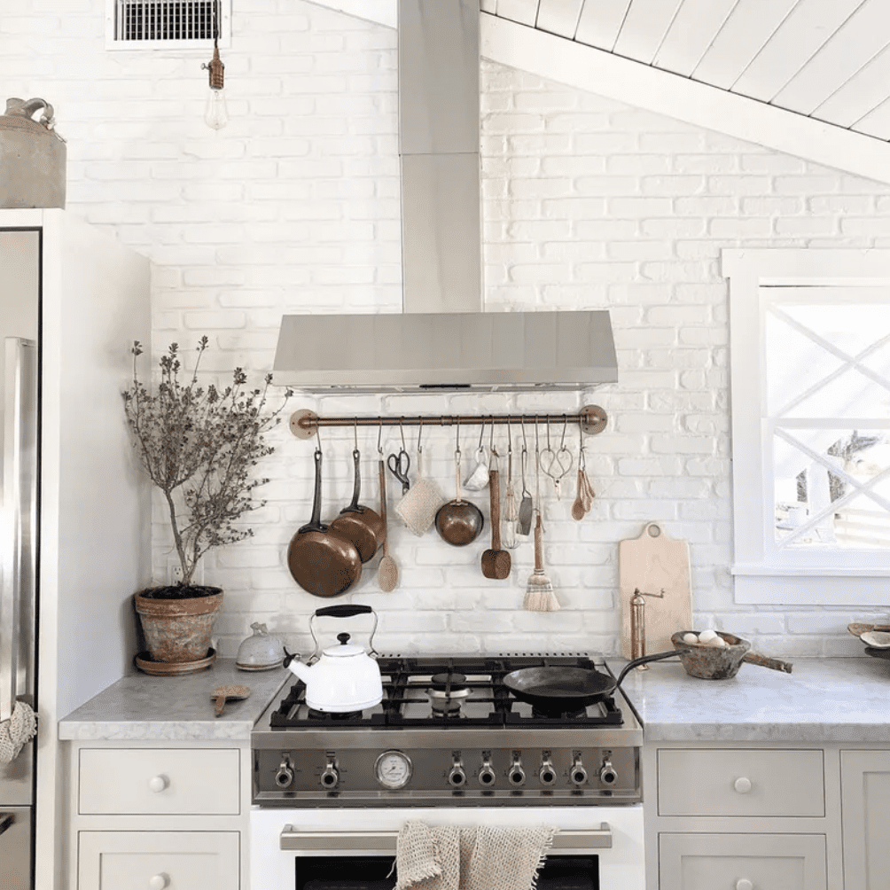 一个带有倾斜的天花板的小白色厨房和一块塑料罩的卷尺