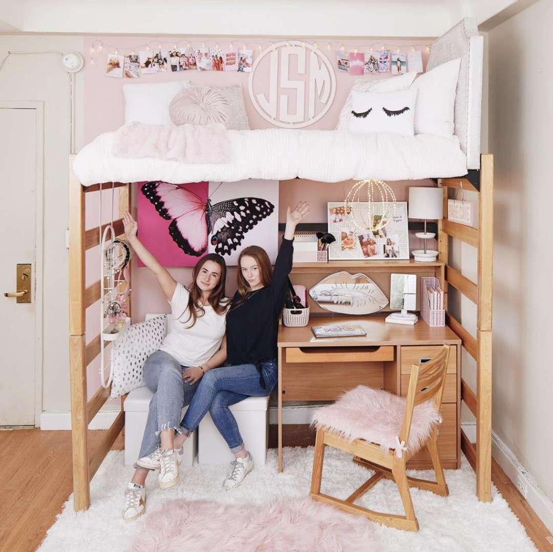 两个女孩躺在她们高耸的宿舍床下。