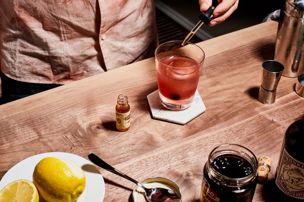 有人在木头桌子上用苦艾酒调制鸡尾酒。