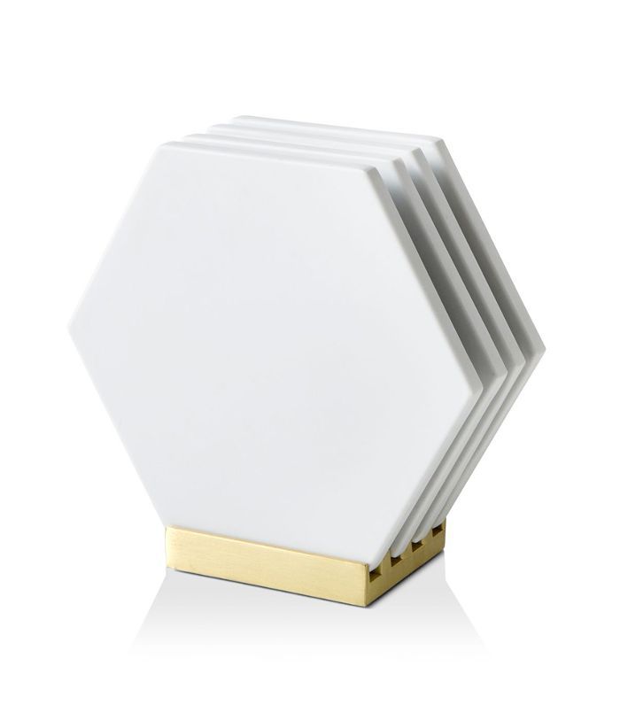 一组四个白色杯垫上金色调的立场直立。