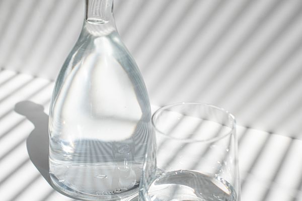 玻璃瓶水在饮用的玻璃旁边