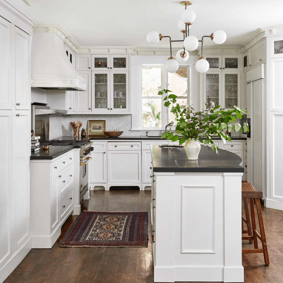 一个小型的白色厨房，拿着橱柜，从天花板到地板