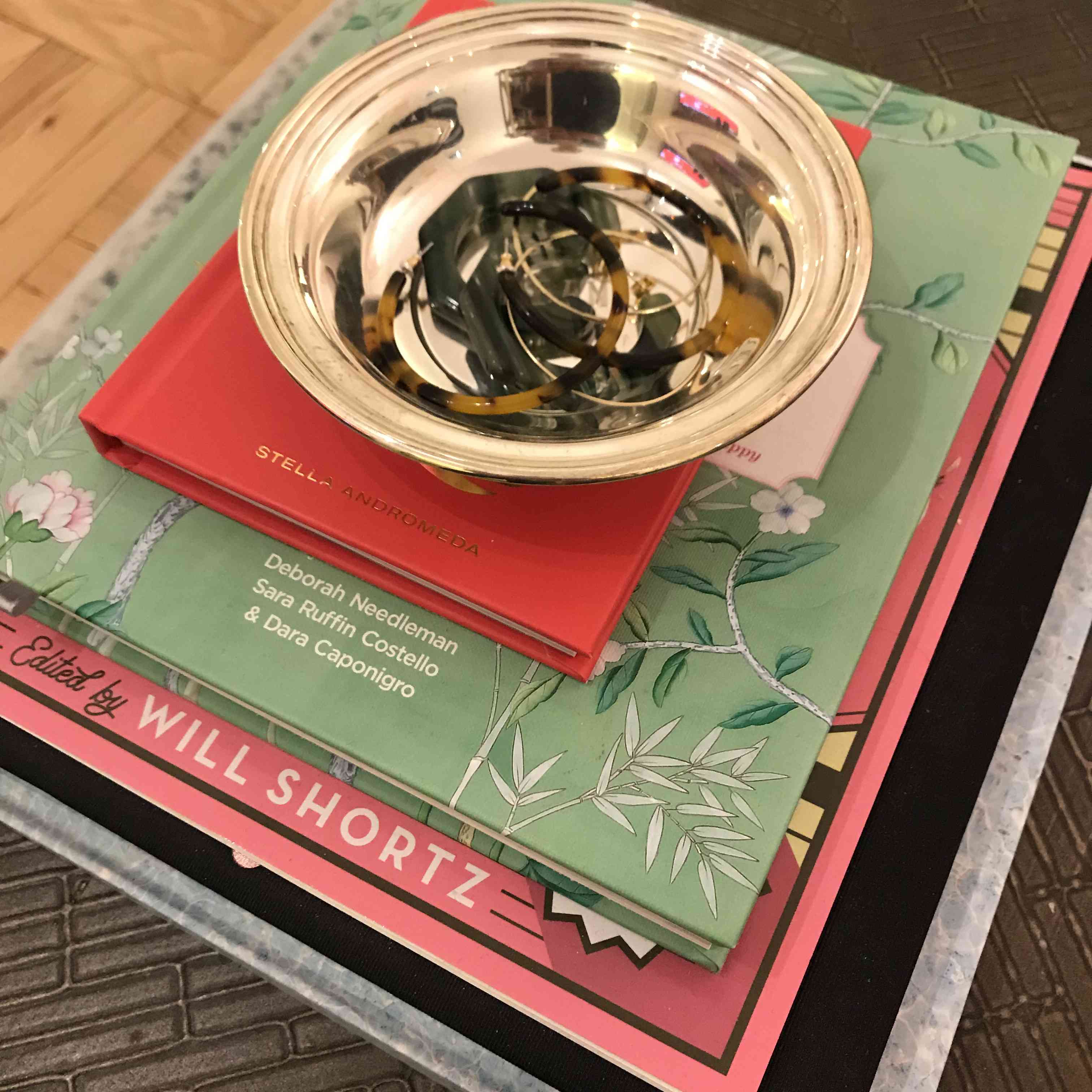 如何混合旧的和新的 - 银色的盘装满书籍顶部的耳环