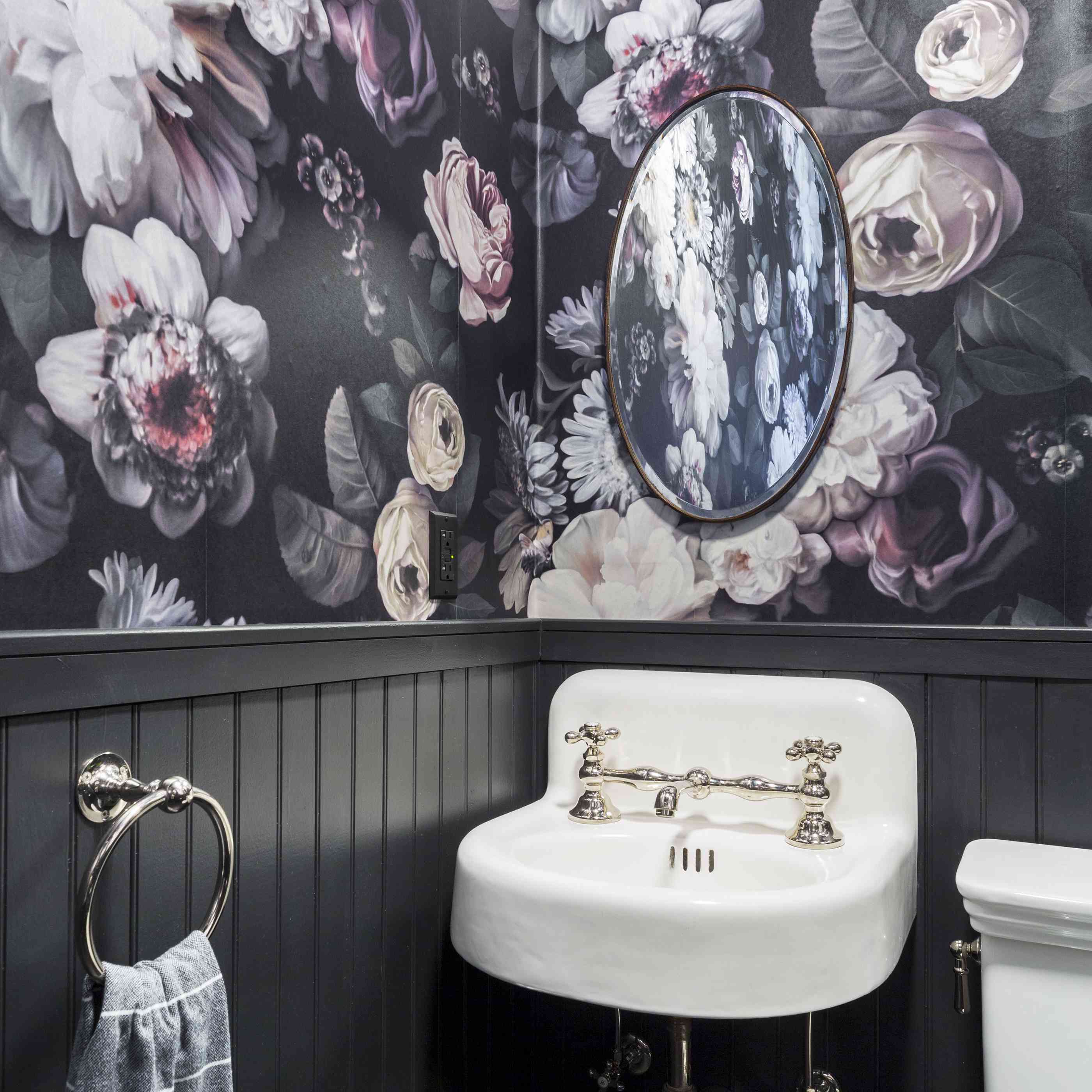 有花卉墙纸的黑浴室。
