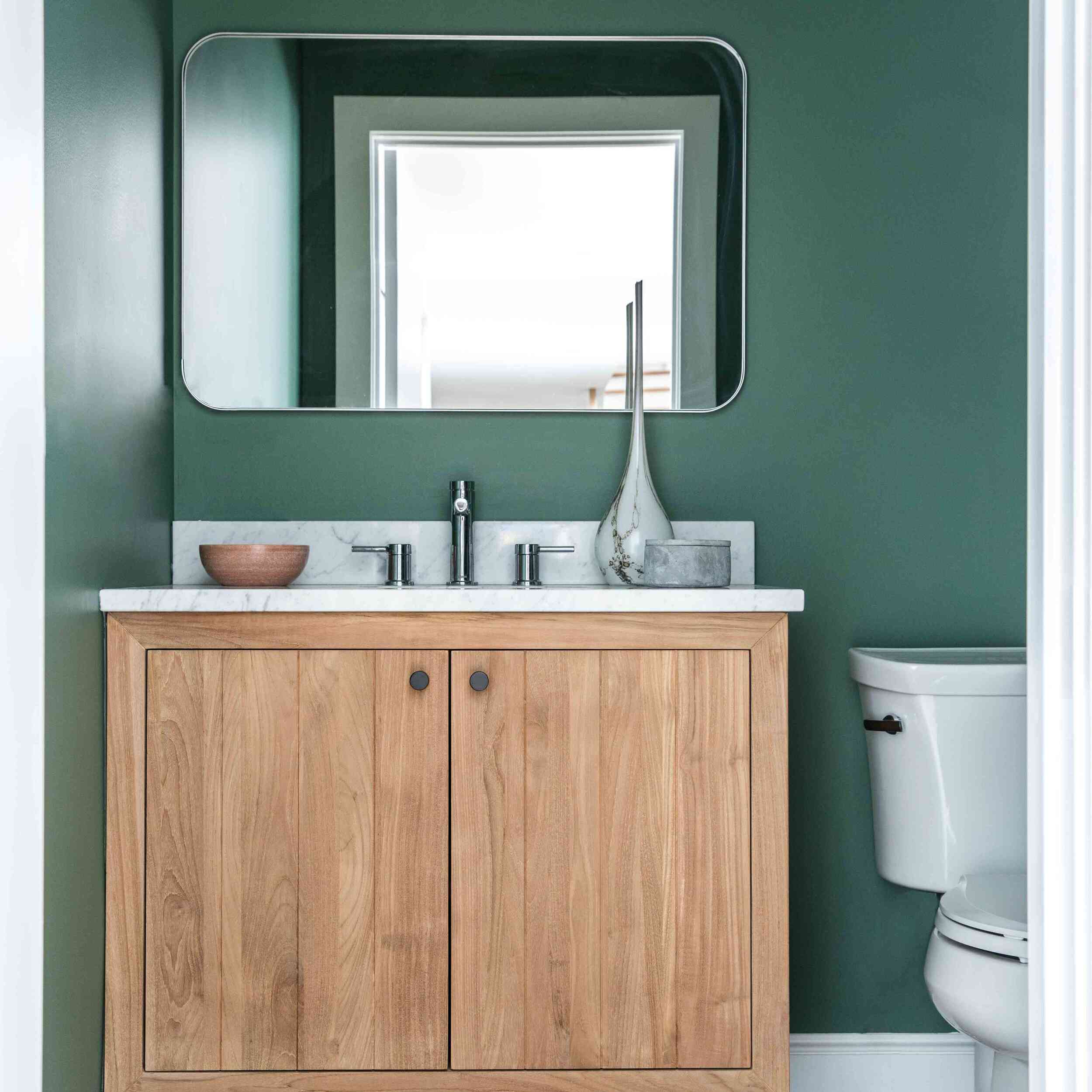 有一半浴室，墙壁是深绿色的