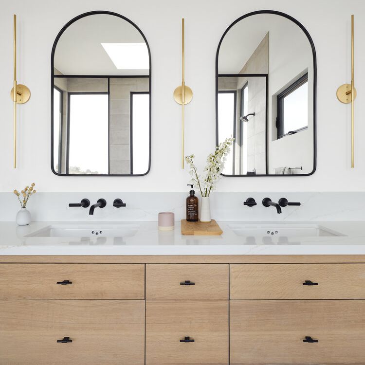 盥洗室里有高高的半圆形镜子和同样高的窄壁灯