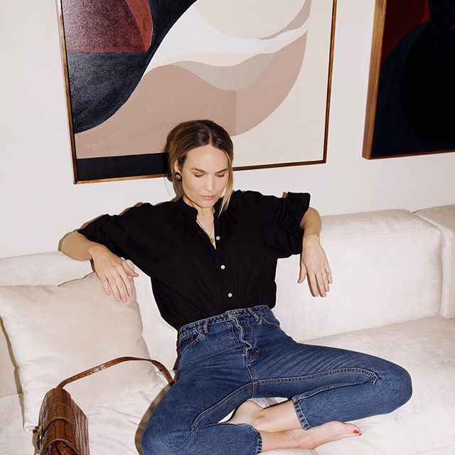 一个女人沉思与她的腿沙发折叠和闭眼。