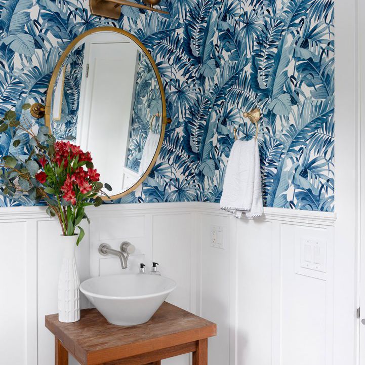 浴室配有蓝色壁纸和小型基座水槽