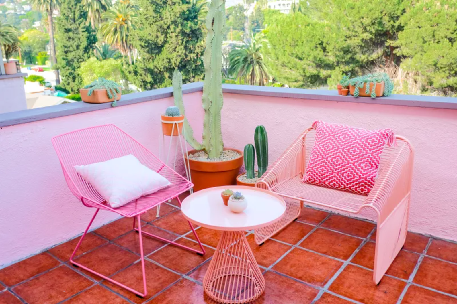 带红色瓷砖地板，粉红色墙壁和粉红色家具的阳台