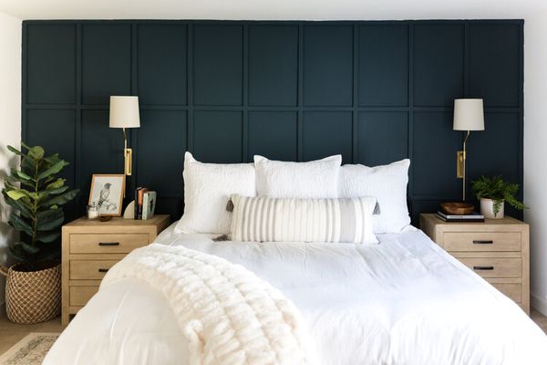 白色的床上用品靠在深蓝色的墙上