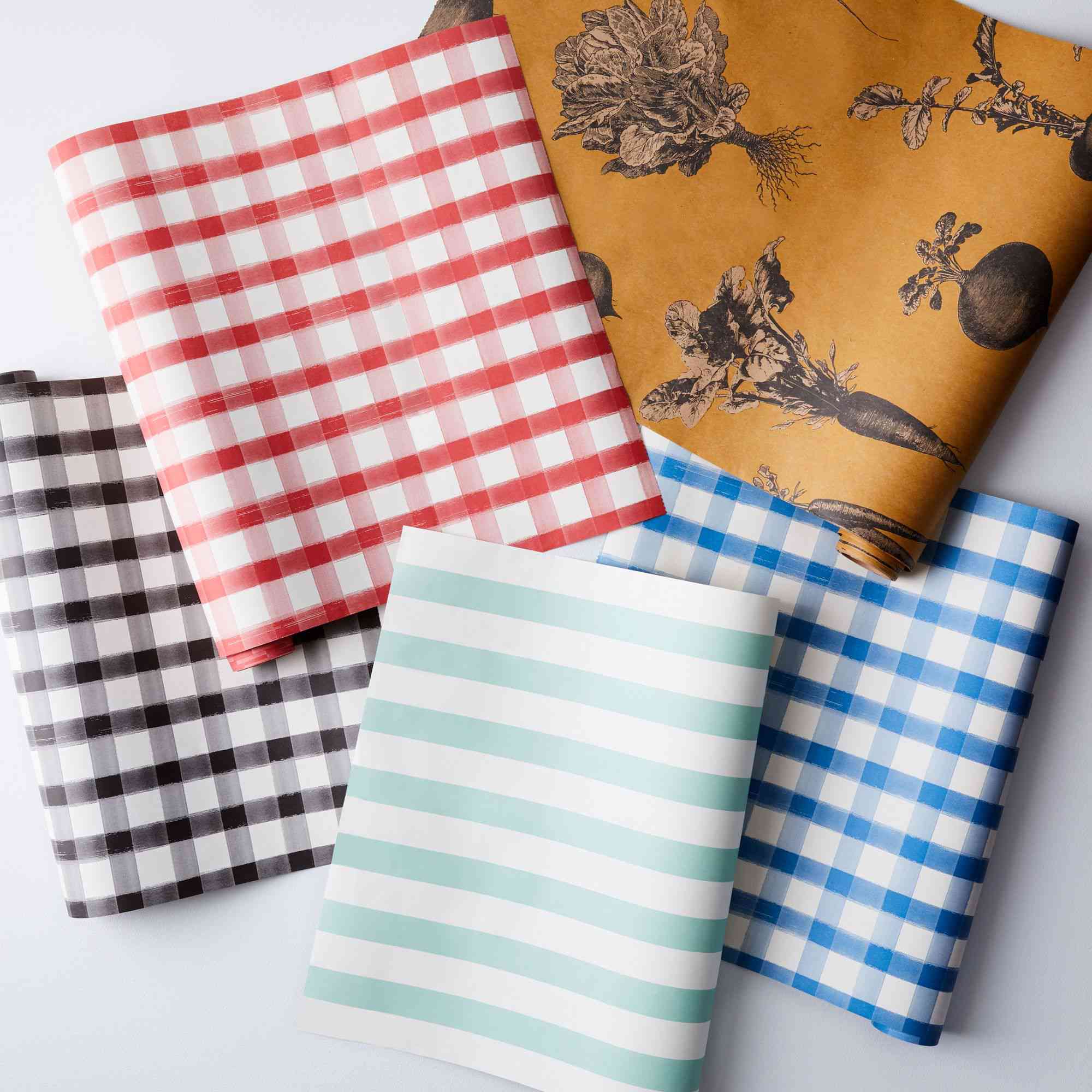 红色、棕色和蓝色的格子纸桌布，旁边是橙色、白色和水蓝色的条纹桌布。