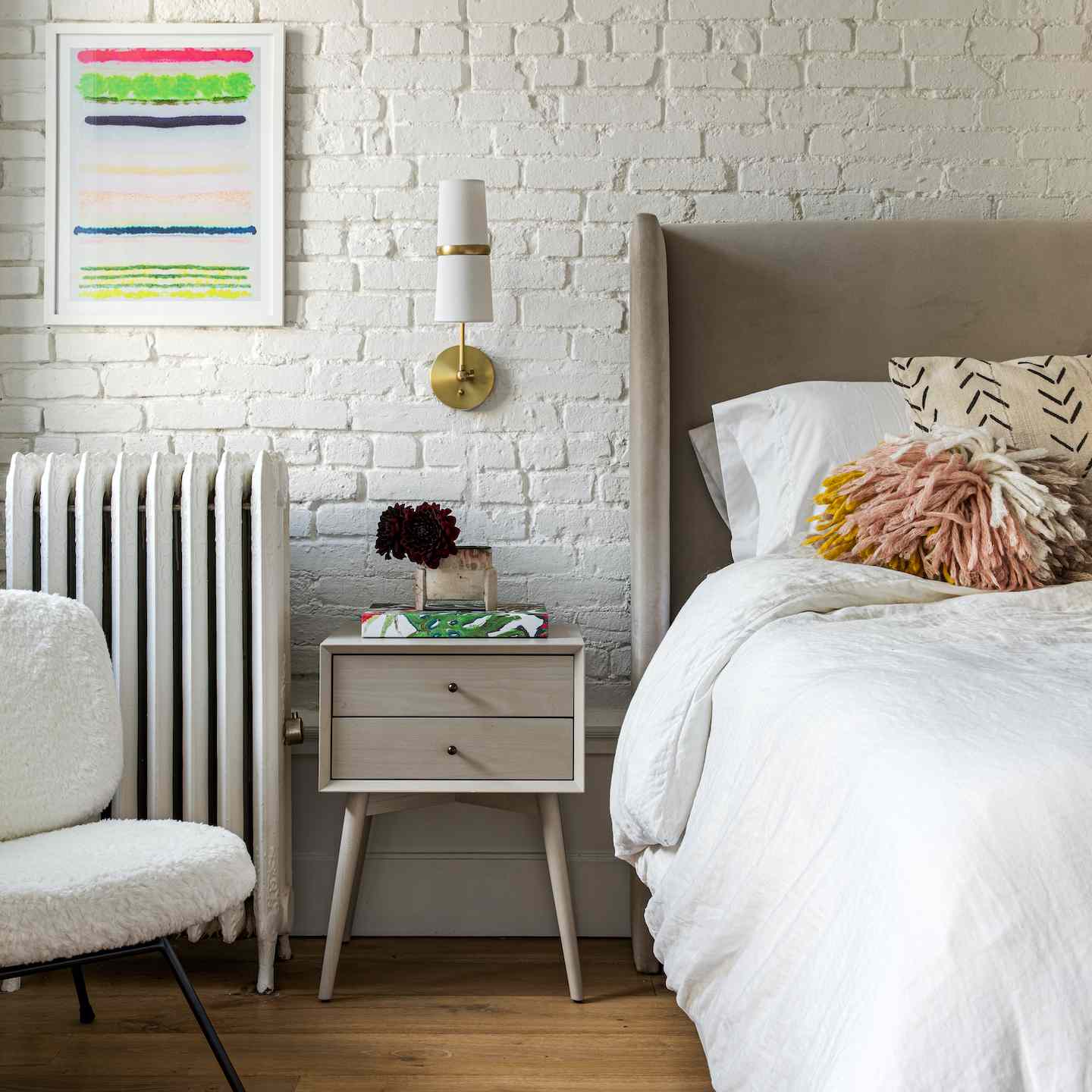 反对白色砖墙的白色床。