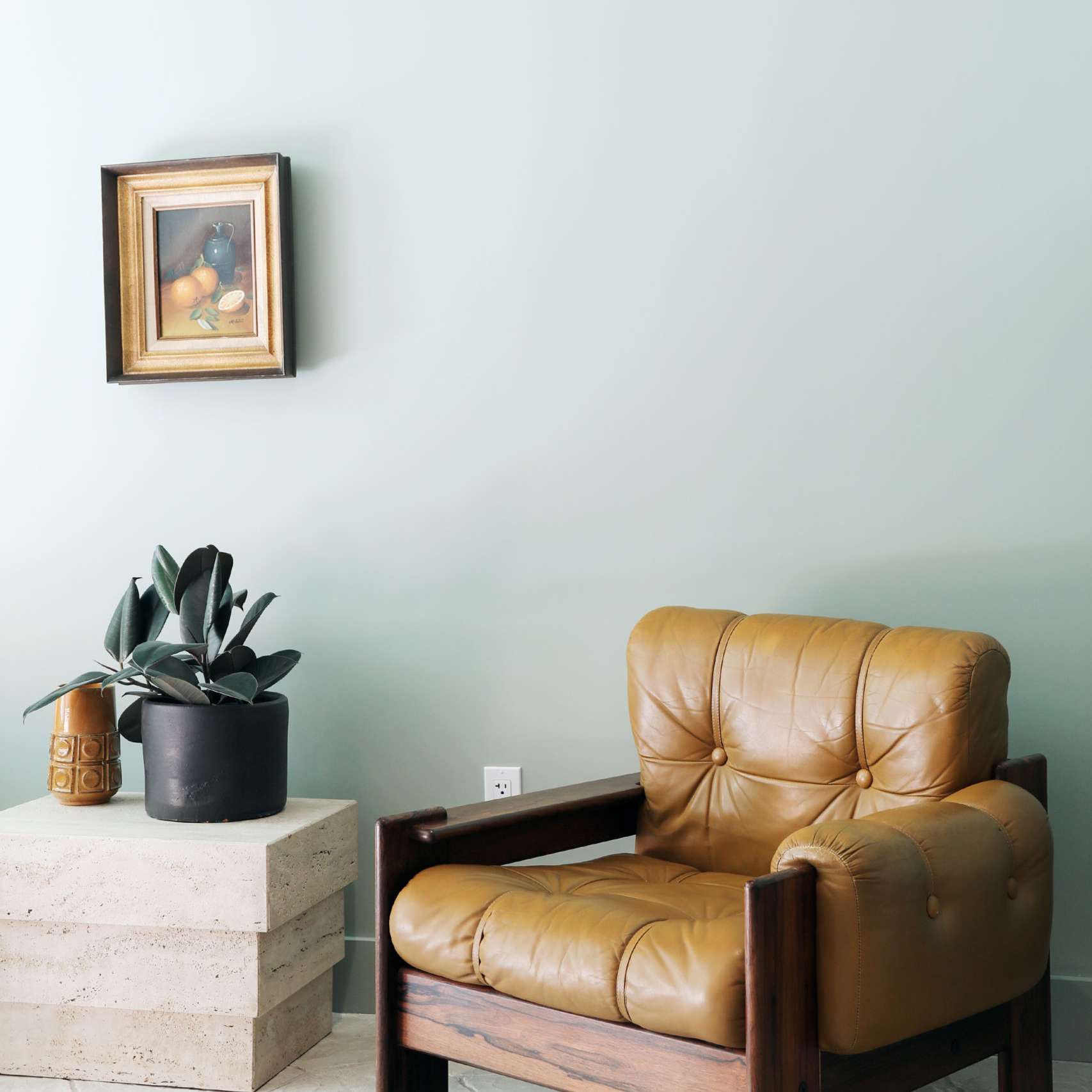 一个世纪中叶现代皮革躺椅一个具体的边桌，盆花，和陶瓷花瓶。