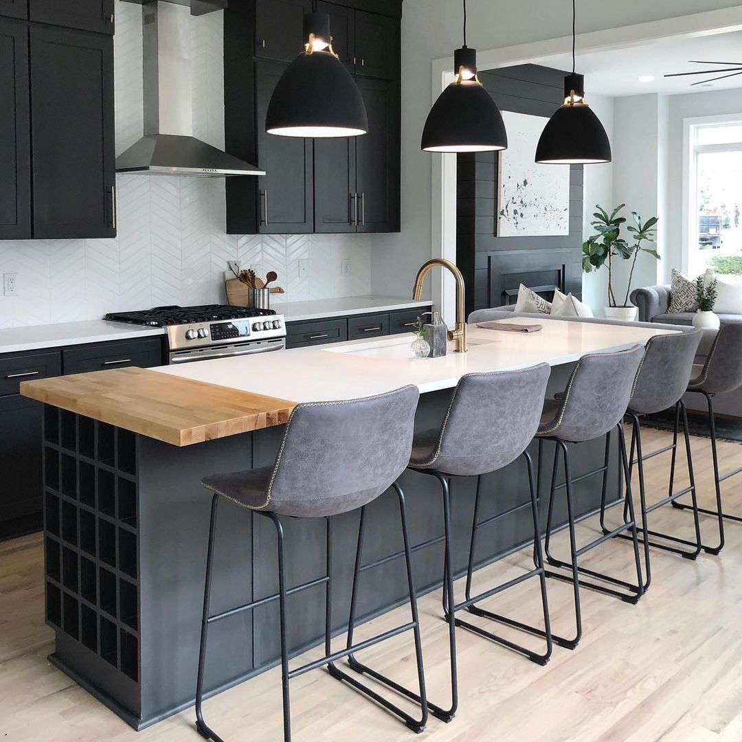 漂亮干净的厨房用黑色吊坠照明设备在岛上。