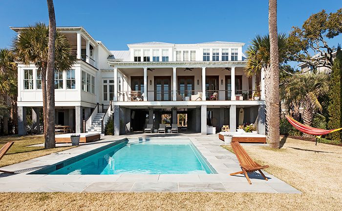 立德家园的外观，包括游泳池和覆盖天井，和一个吊床斜背棕榈树之间