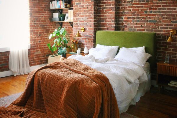 砖墙前的绿色床头床。