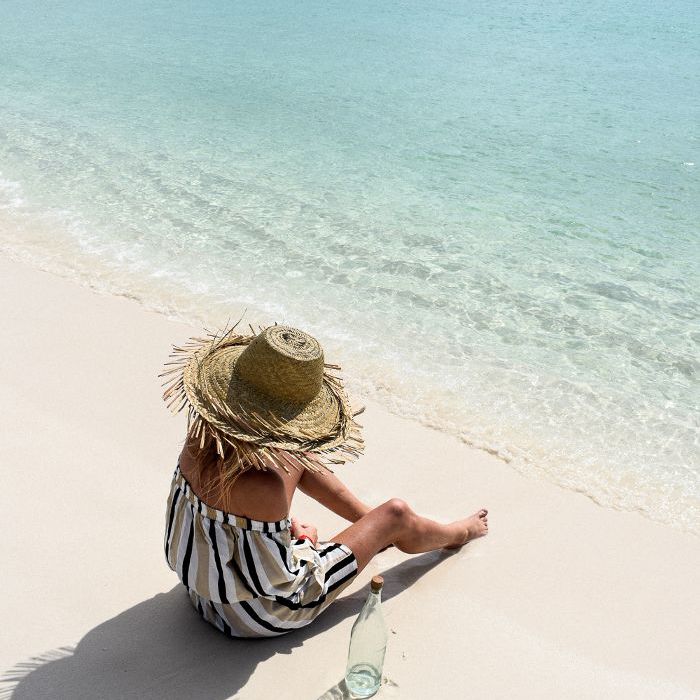 一个女人坐在沙滩在波多黎各别克斯岛上。