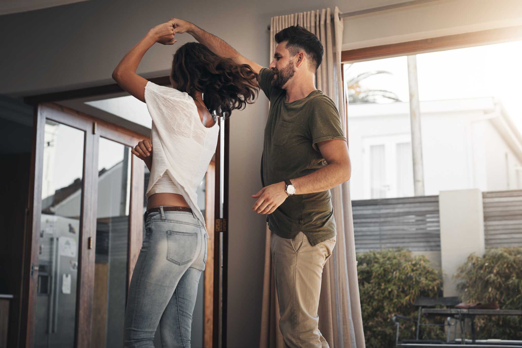 在家里幸福的年轻夫妇跳舞的一起枪杀