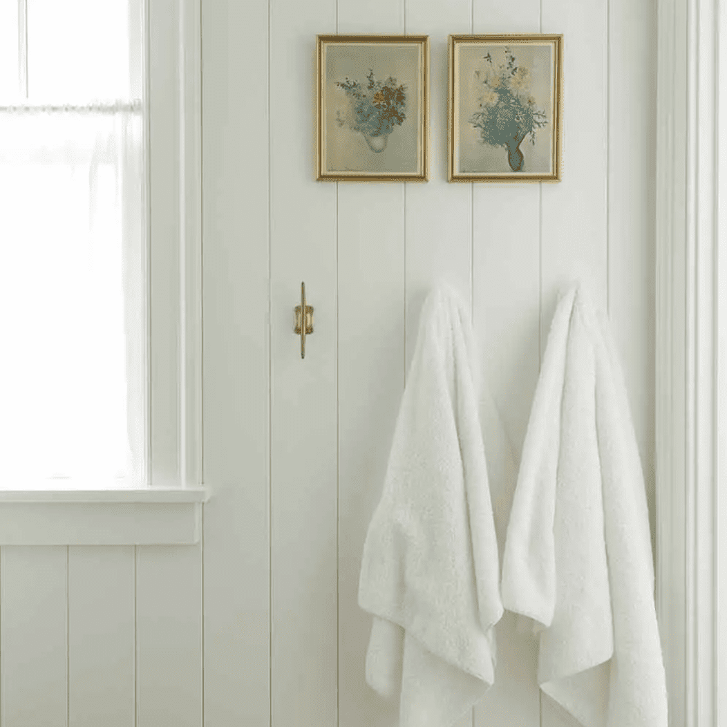 一间镶着木板的浴室，装饰着两幅小小的古画