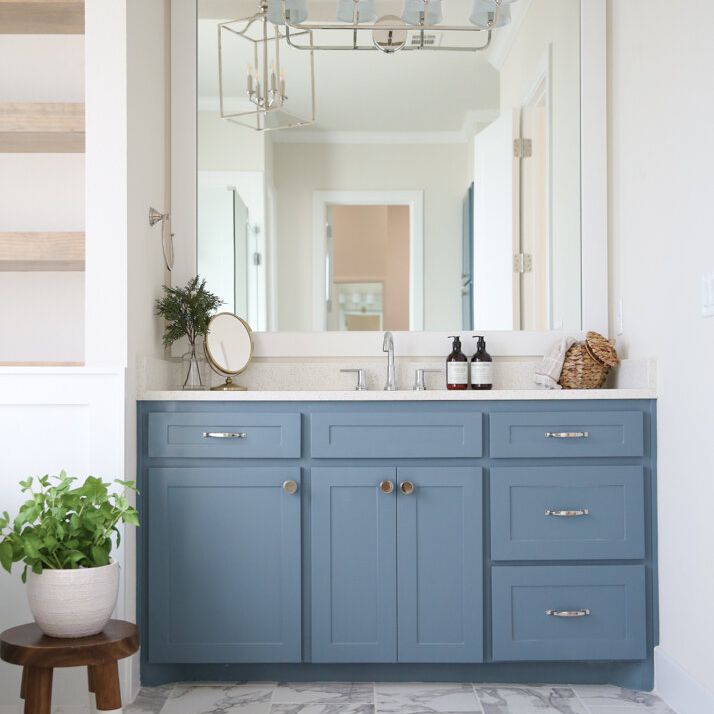 浴室里的蓝色梳妆台配有大镜子