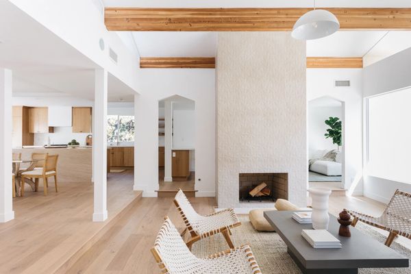客厅有有纹理的壁炉，木梁和白色的木制家具