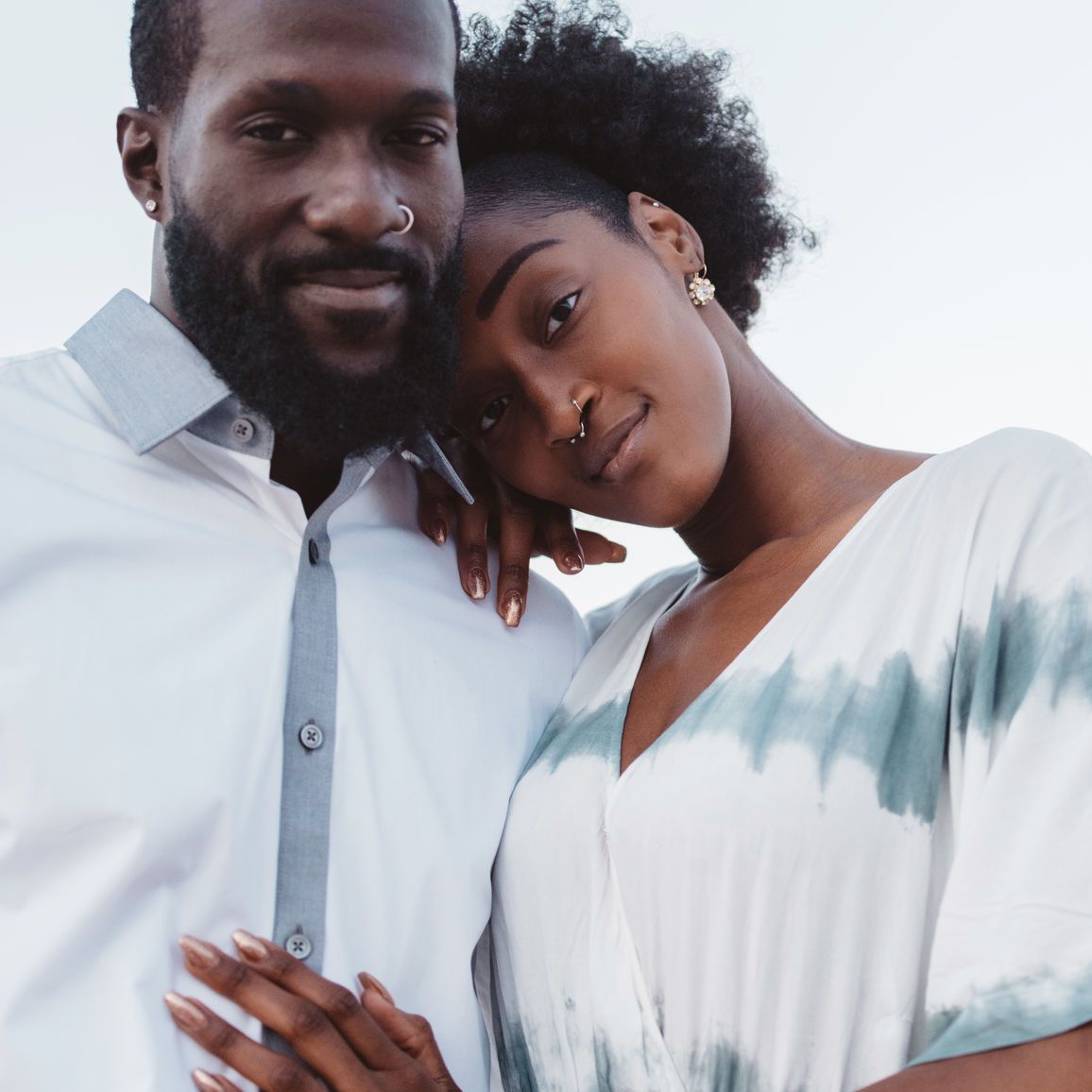 一对夫妇站在彼此相邻，手互相拥抱