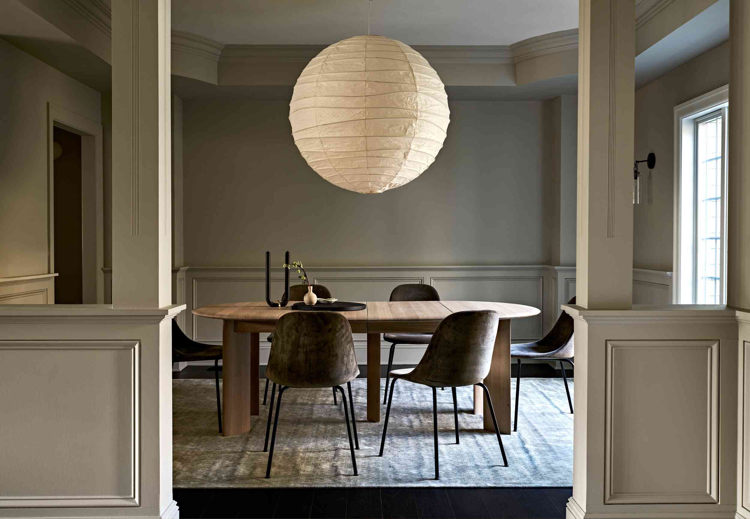 一间配有时髦家具和一盏超大球形灯的餐厅