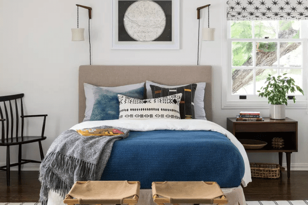 卧室有许多存储解决方案，包括一个床头柜、一个篮子和两个行李架（放在床脚）