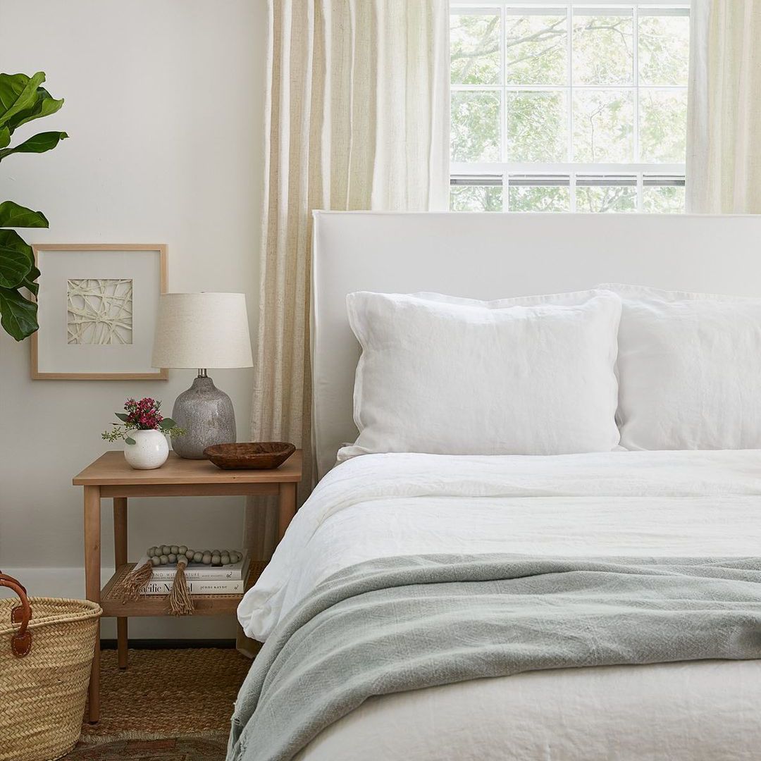 柔和的中性卧室，阳光透过窗户照射进来。