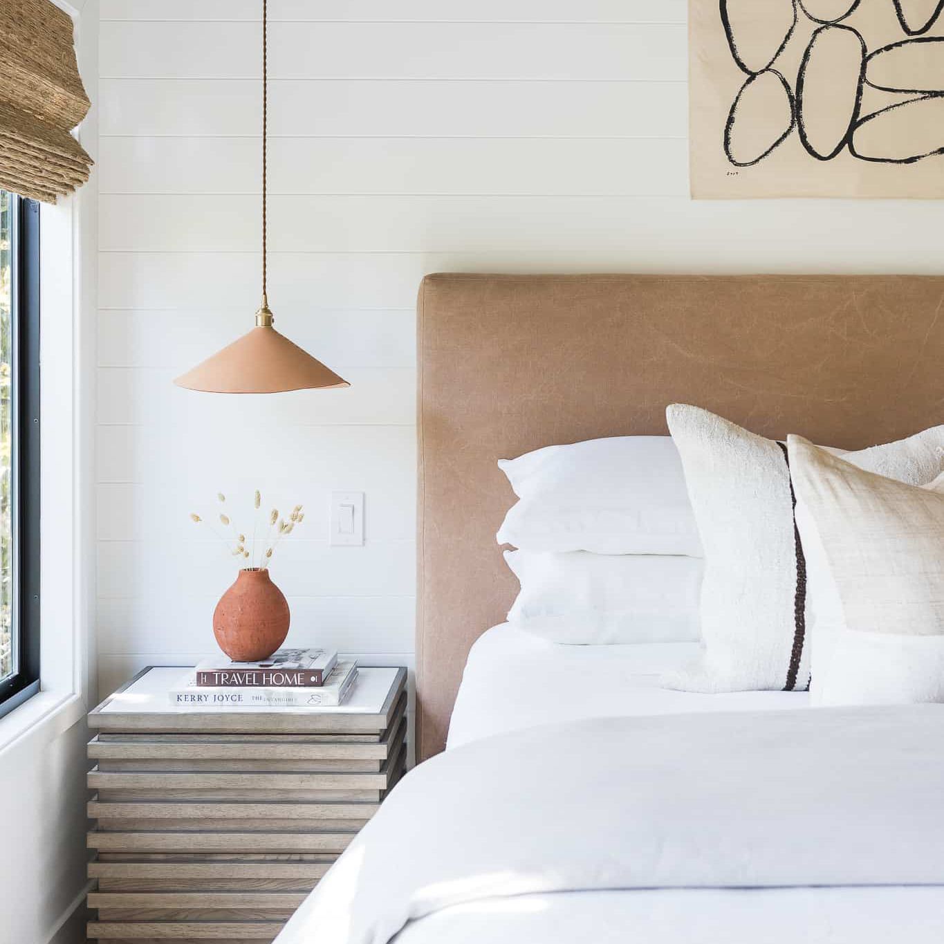 一间现代卧室，配有毛绒皮革床头板