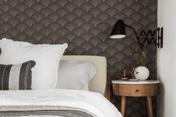 卧室有黑色的扇形壁纸和白色的床单。